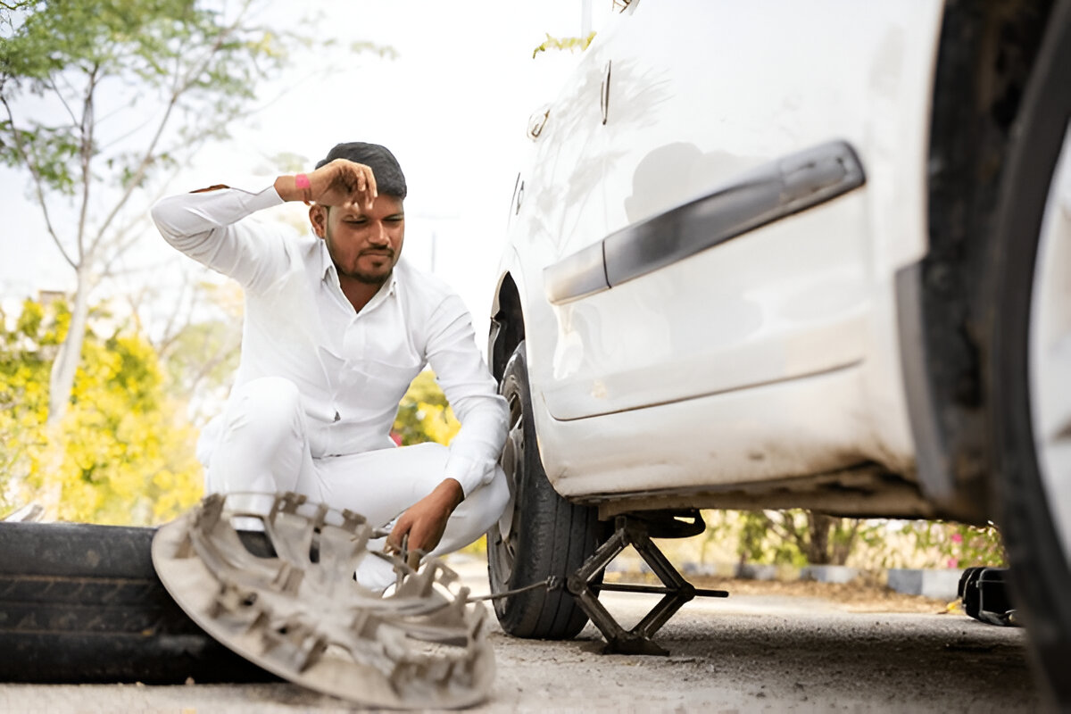 tyre puntured of man sitting on road